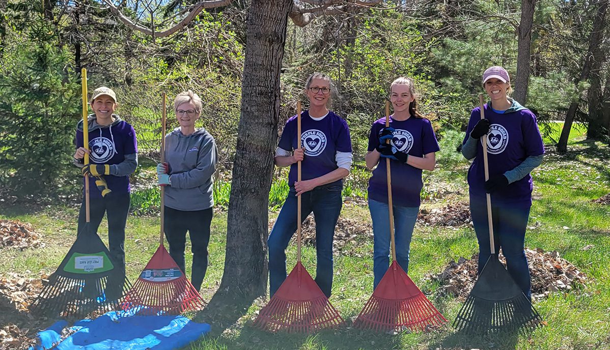 Purple Squad group raking leaves